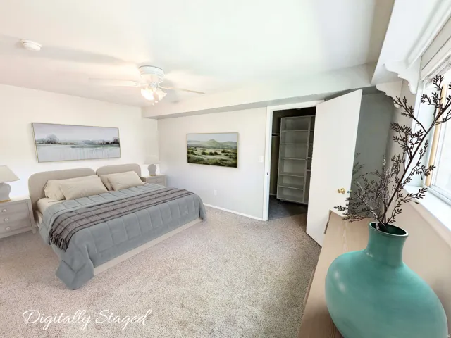 Plush carpeting, ceiling fan with light fixture, built-in closet shelving, and a window with trim