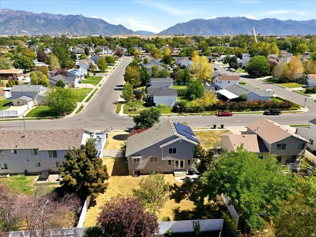 Two-story residence with a gray exterior, solar panels, and a gabled roof
