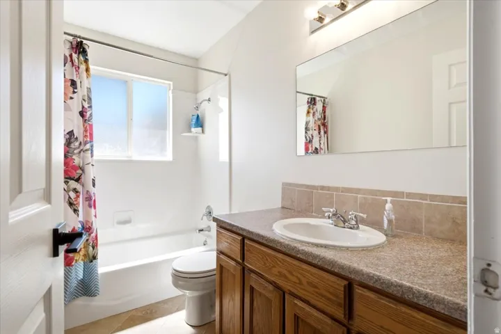 Vanity with wood-finish cabinetry, integrated sink, and laminate countertop