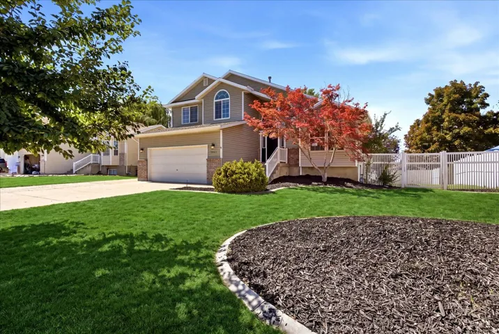 Brick Colonial home with two-story elevation and arched entry featuring a two-car garage