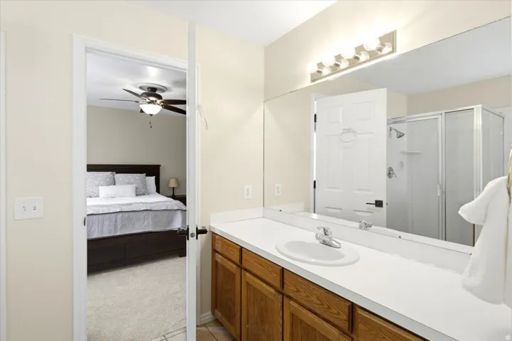 Vanity with a single basin, a chrome faucet, and a large mirror