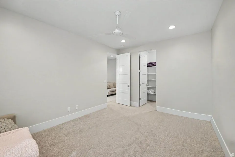 Recessed lighting, ceiling fan, carpeting, built-in shelving, white trim