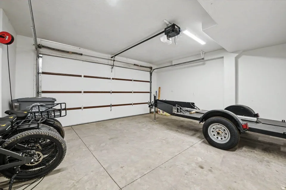 Spacious garage featuring a sectional garage door, concrete flooring, and ceiling-mounted lighting