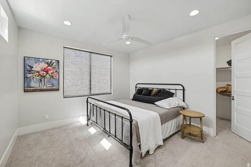 Carpeted flooring, recessed lighting, ceiling fan, window with shades, and a solid core interior door