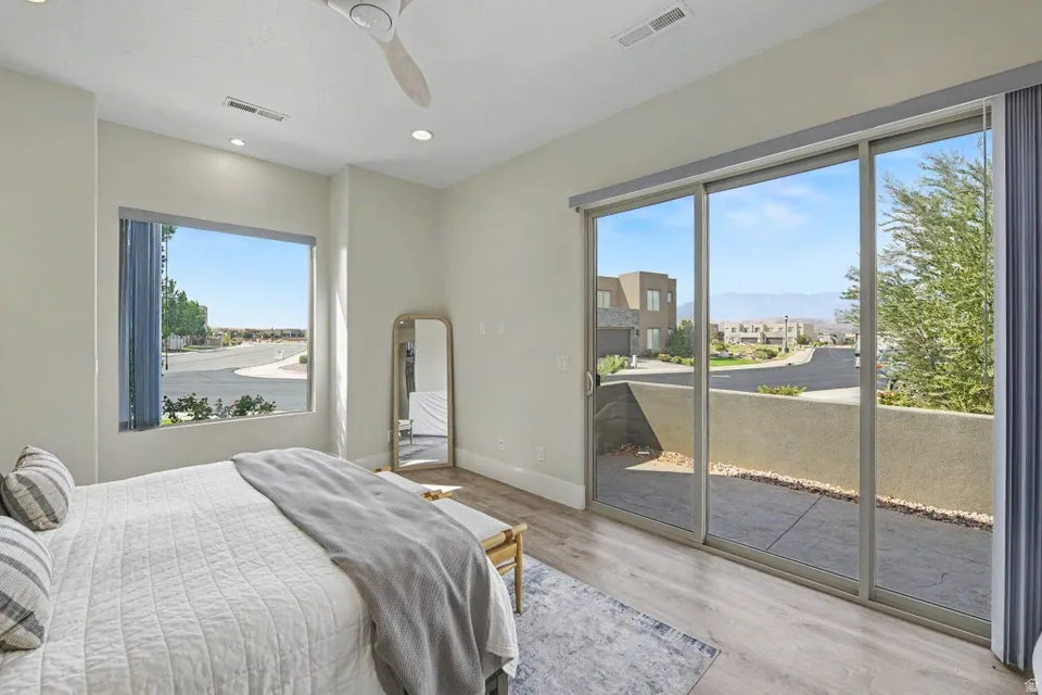 Recessed lighting, ceiling fan, wood-finish flooring, expansive sliding glass doors, and a large picture window