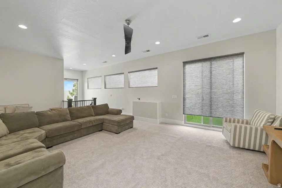 Recessed lighting, ceiling fan, and multiple windows with roller shades