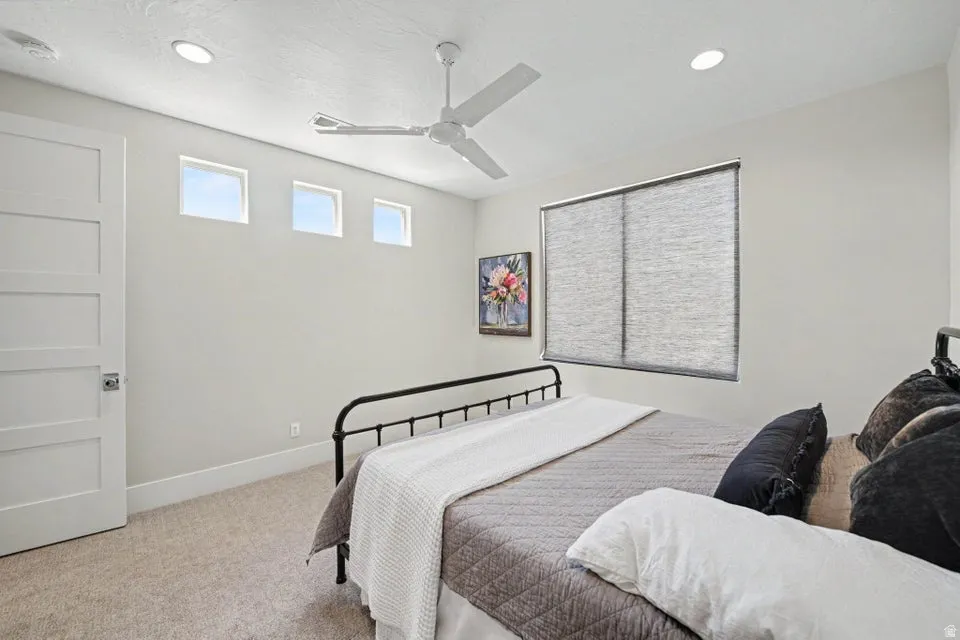 Spacious bedroom featuring carpet flooring, recessed ceiling lighting, and a ceiling fan