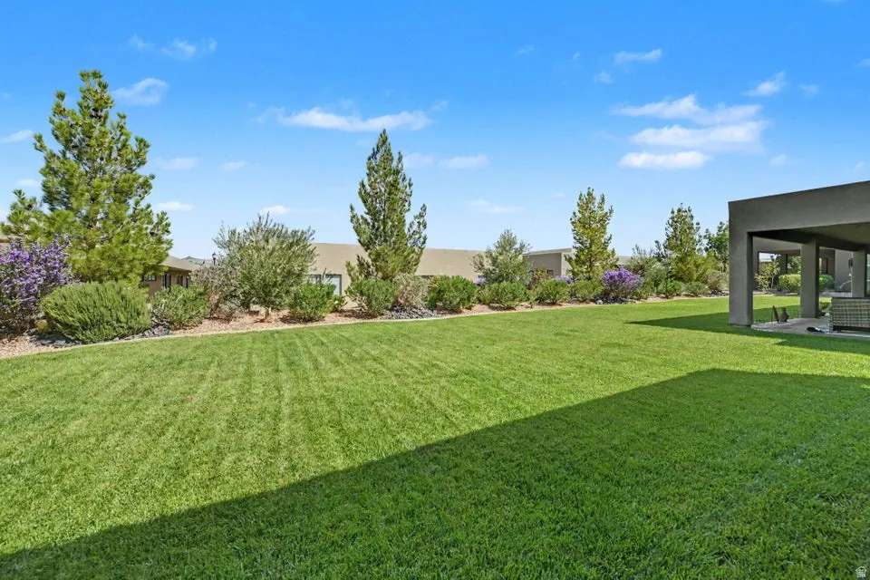 Expansive lawn area with mature landscaping, featuring a covered patio structure
