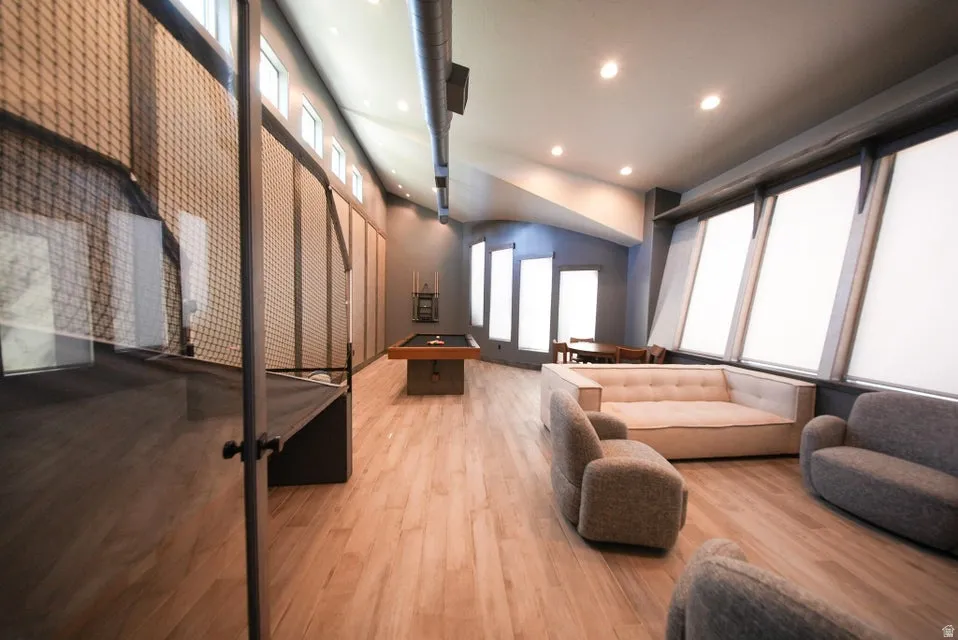 Wood-finish flooring, recessed lighting, and a vaulted ceiling with exposed ductwork