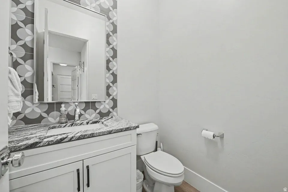 Vanity with a polished stone countertop, integrated sink, and modern cabinetry