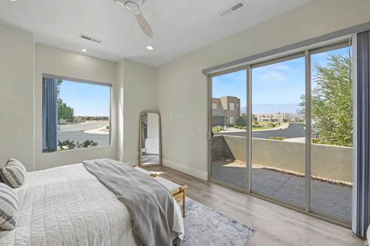 Recessed lighting, ceiling fan, wood-finish flooring, expansive sliding glass doors, and a large picture window