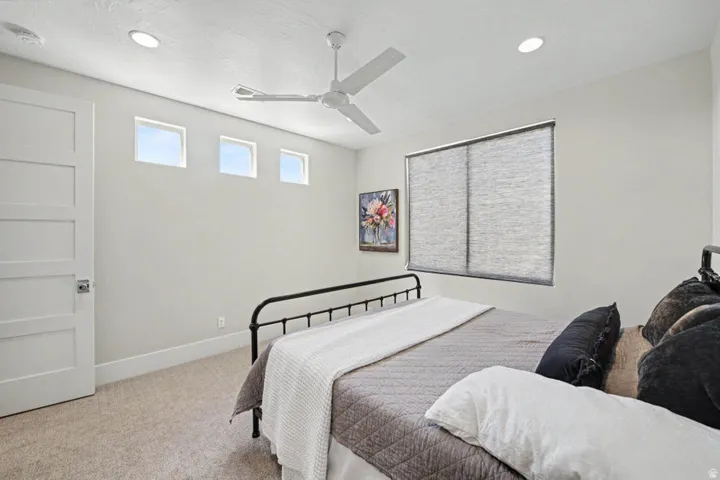 Spacious bedroom featuring carpet flooring, recessed ceiling lighting, and a ceiling fan