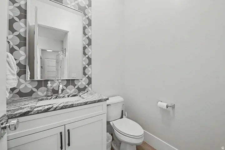 Vanity with a polished stone countertop, integrated sink, and modern cabinetry
