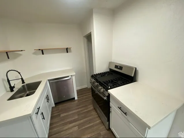 Kitchen featuring white shaker cabinetry, light-toned countertops, a stainless steel gas range, and a stainless steel dishwasher