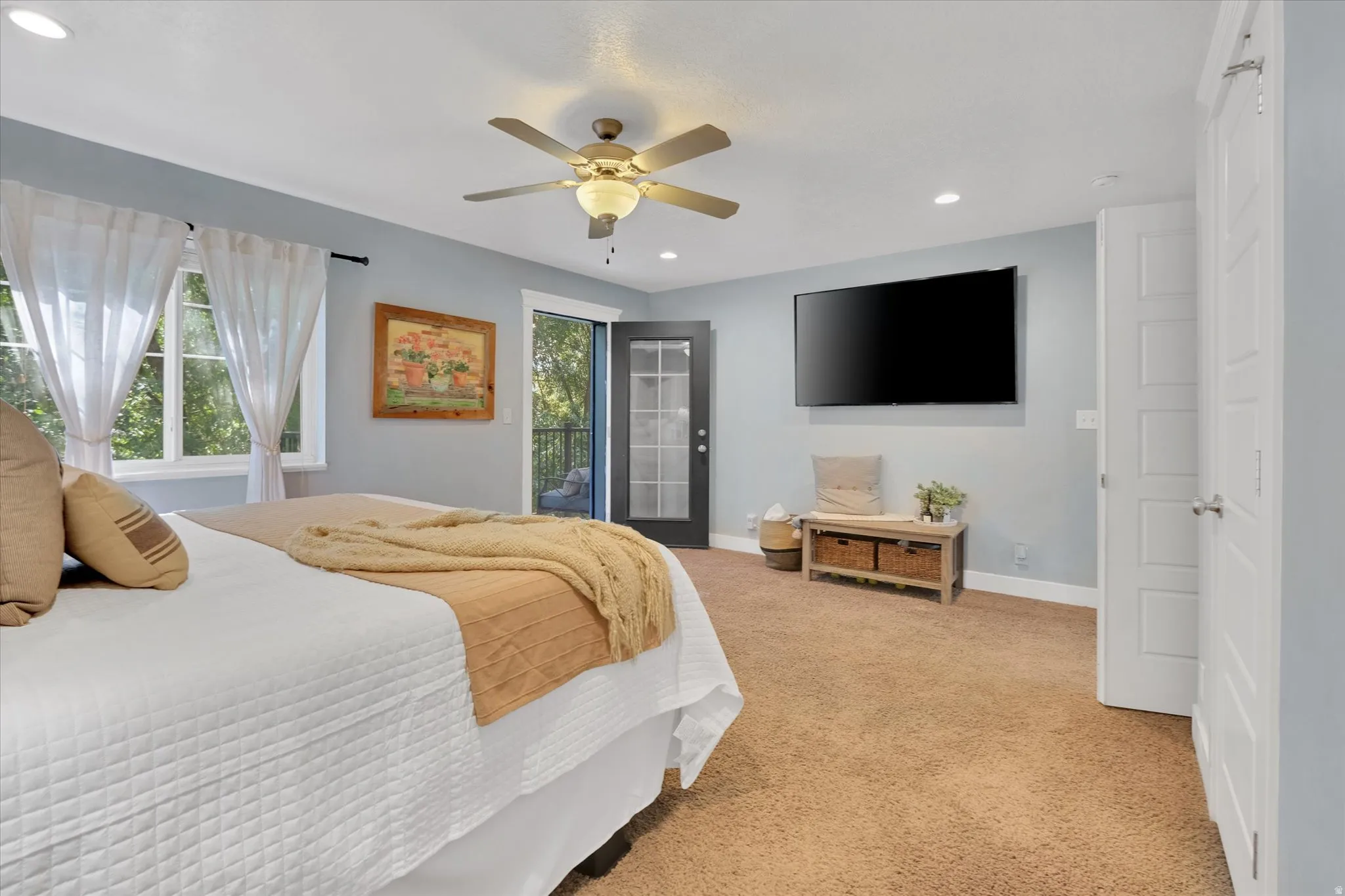 Windowed exterior door, ceiling fan with integrated lighting, recessed lighting, and light-colored wall paint