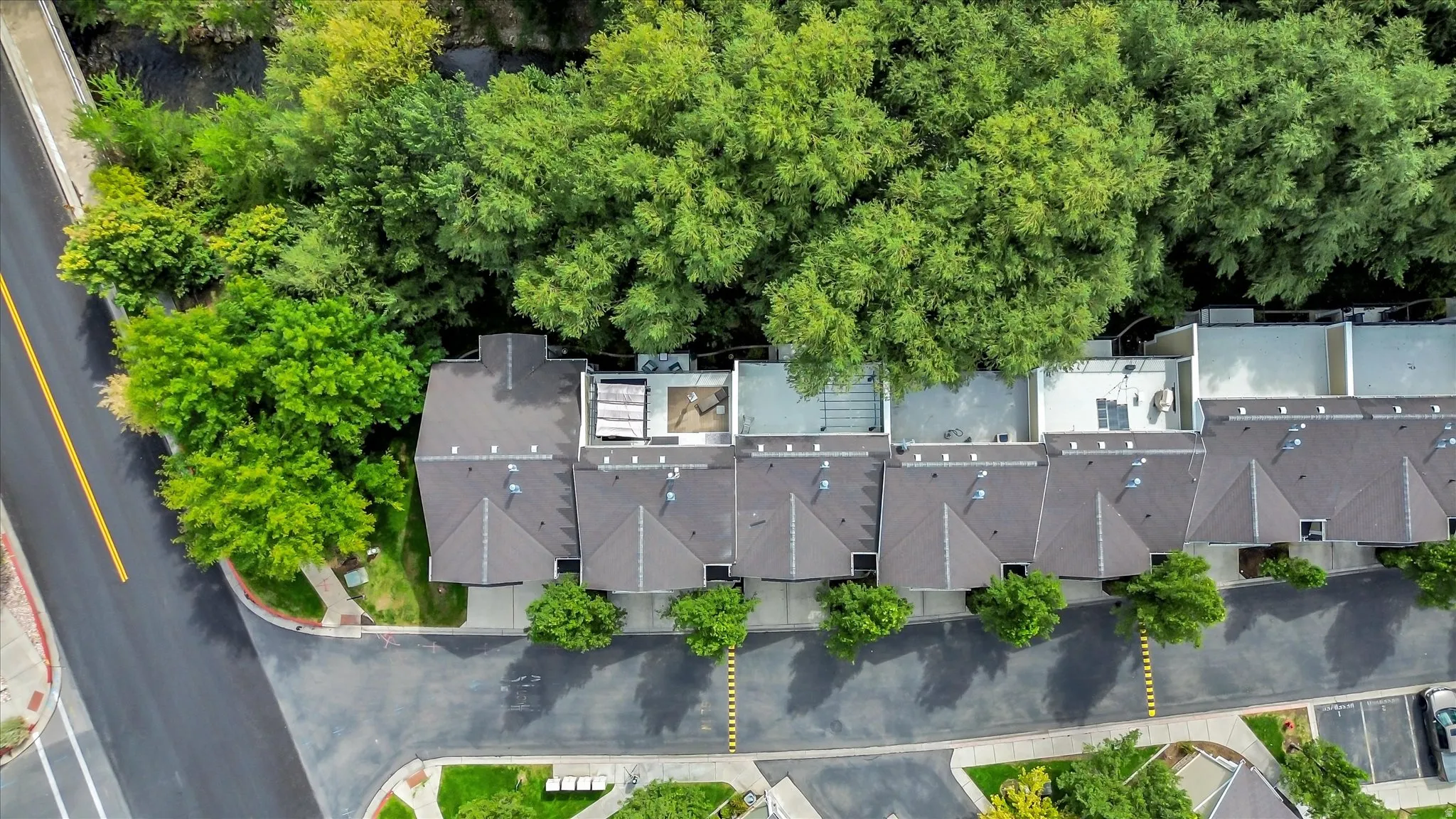 Townhome row with pitched shingle roofs and integrated rooftop patios
