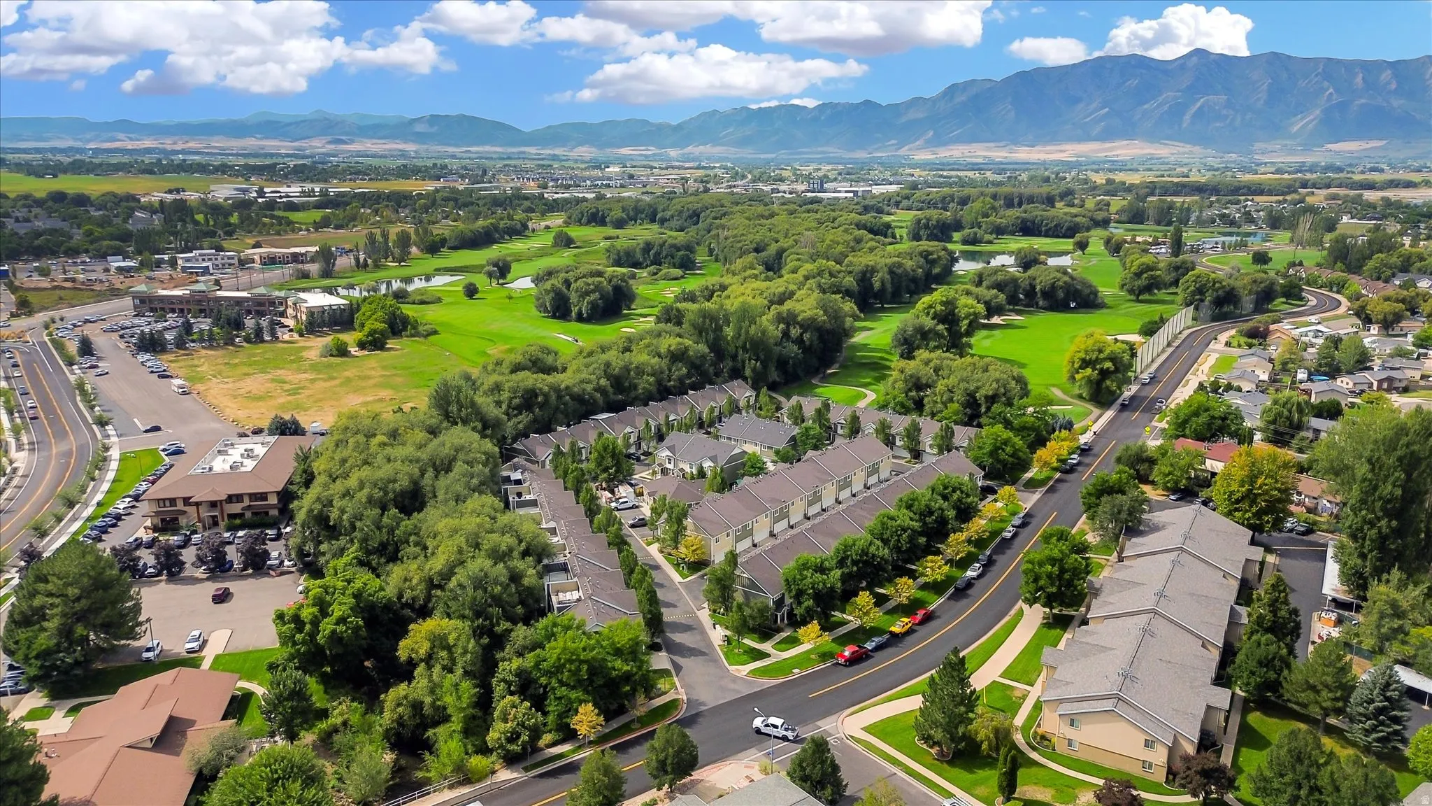 Aerial perspective showcasing mountain backdrop, golf course, and residential community