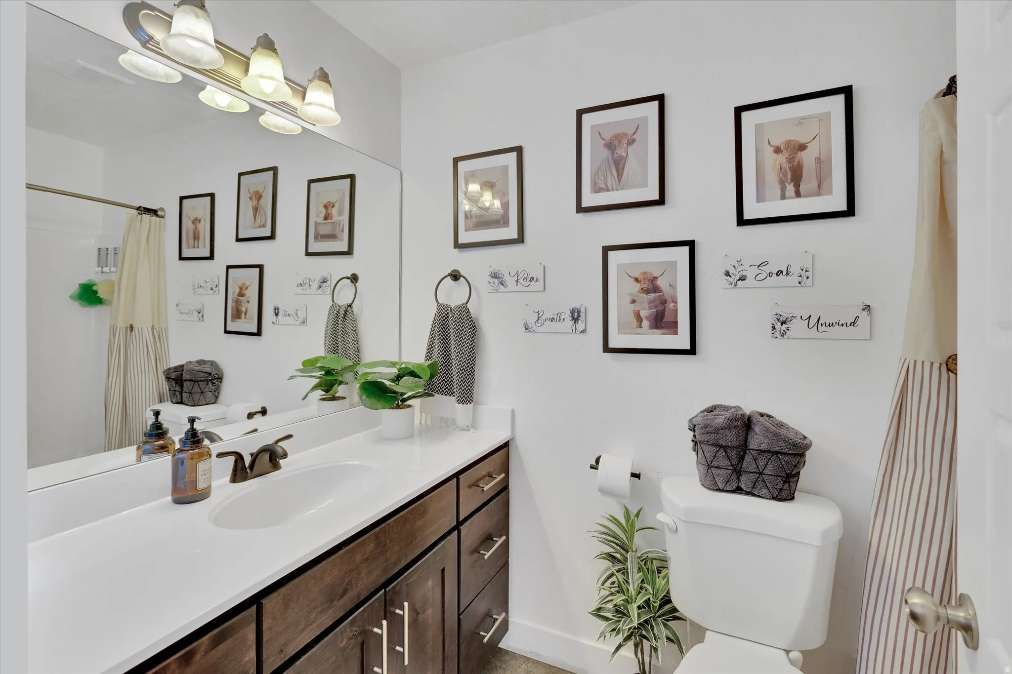 White vanity countertop with an integrated sink, dark wood-finish cabinetry, and a bronze-finish faucet