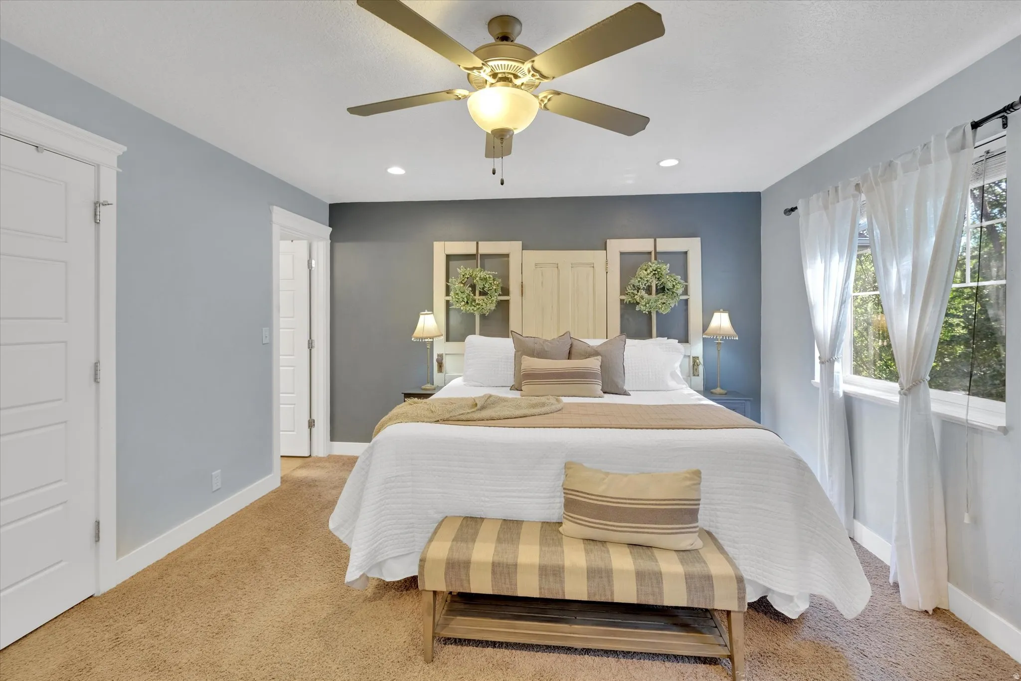 Recessed ceiling lighting, ceiling fan with integrated lighting, wood-finish flooring, white paneled doors, and large windows