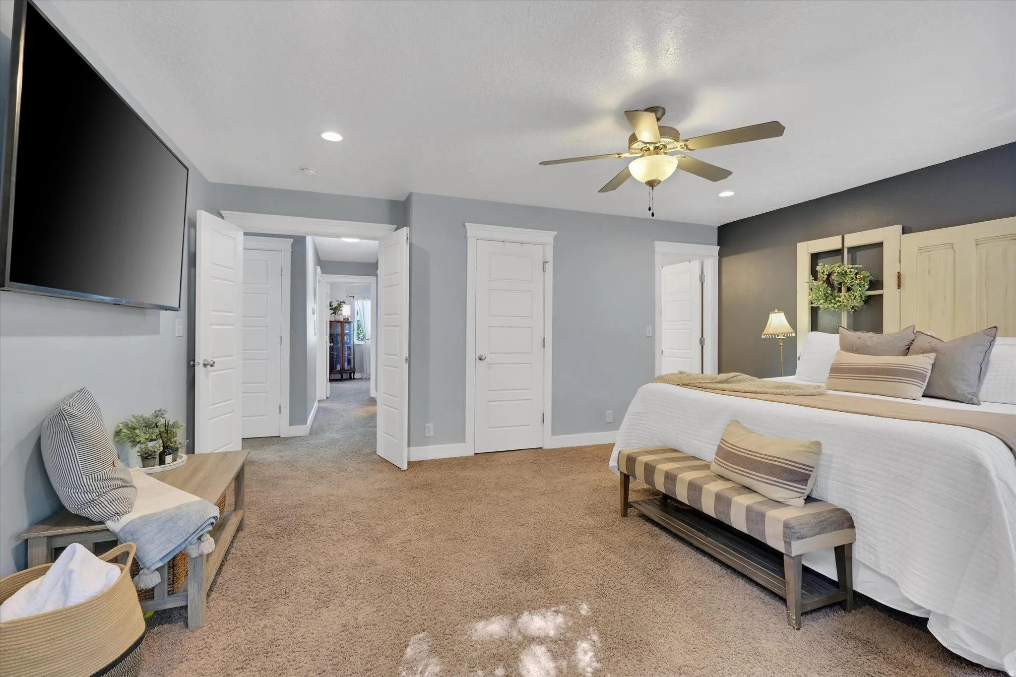 Recessed lighting, ceiling fan, carpet flooring, multiple panel doors, and a wall-mounted television