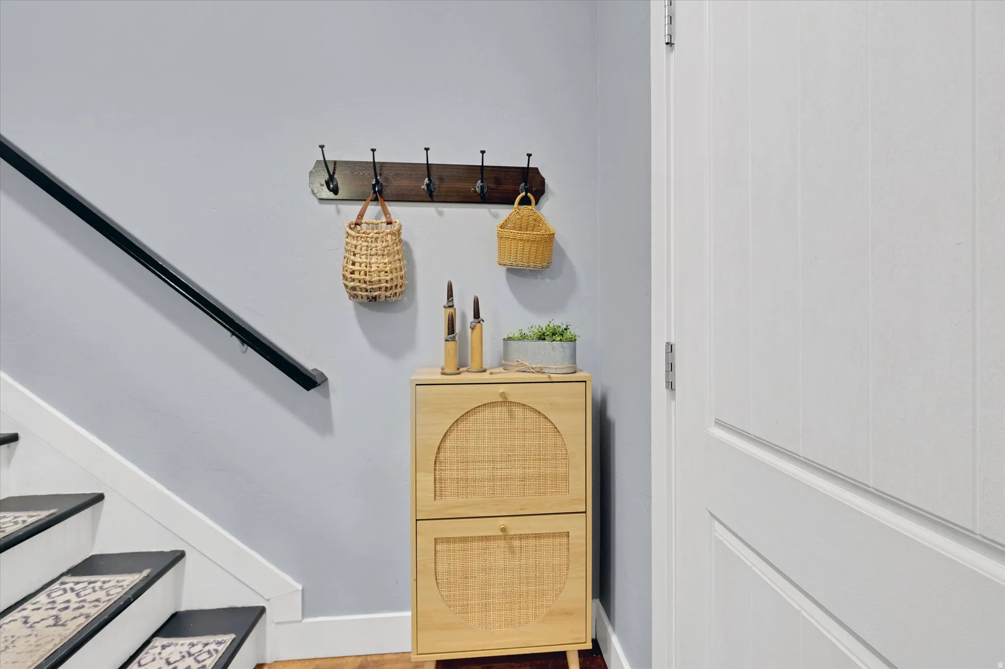 Light gray wall paint, white trim, and a black handrail