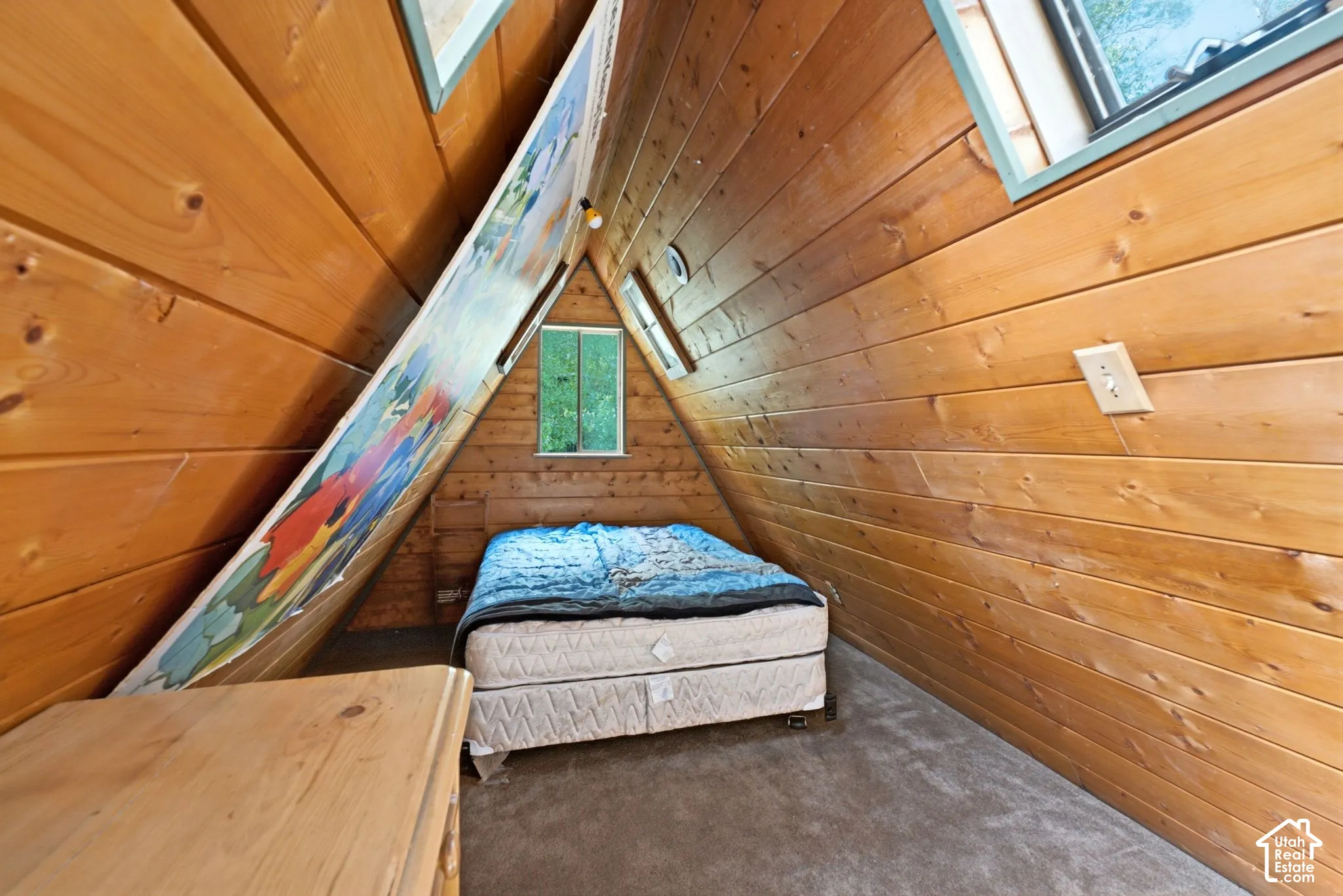 Wood paneling throughout, dormer window, and sloped ceiling