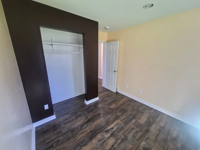 Wood-finish flooring, recessed ceiling lighting, and a neutral wall color