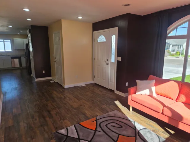 Wood-finish flooring throughout, recessed lighting, and a front entry door with decorative glass inserts