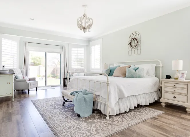 Hardwood-finish flooring, sliding glass door with outdoor access, white plantation shutters, decorative ceiling light fixture, and crown molding