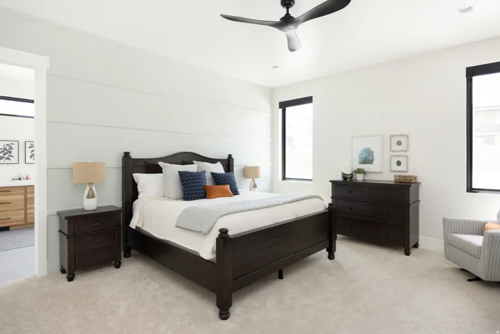Light-toned carpeting, black framed windows, and a black ceiling fan with integrated lighting