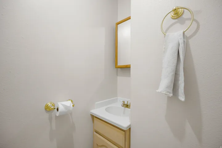 Vanity with integrated sink, brass-finish faucet, and coordinating hardware
