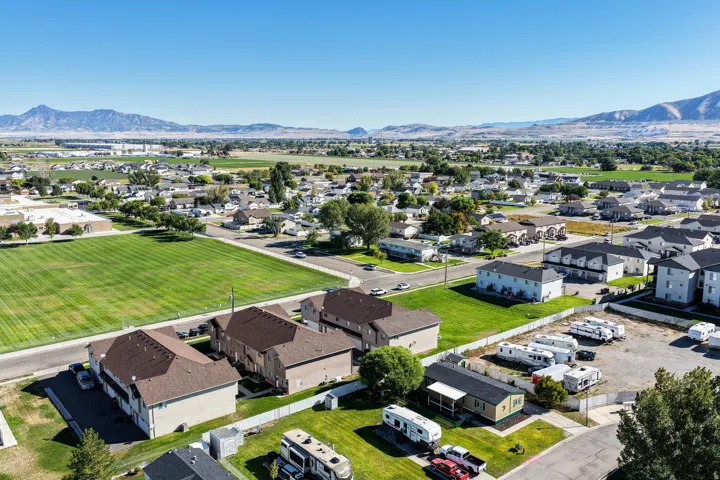 Expansive community featuring multiple residential structures and green spaces, set against a backdrop of distant mountains