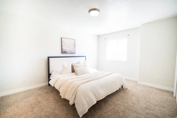 Primary room with window with blinds, wall-to-wall carpeting, overhead flush mount light fixture, and white wall finishes