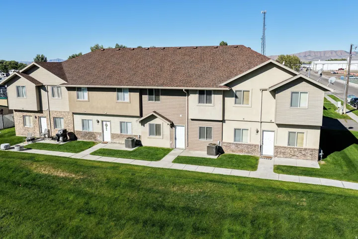 Multi-unit structure with varied siding materials, individual entries, and a shingle roof