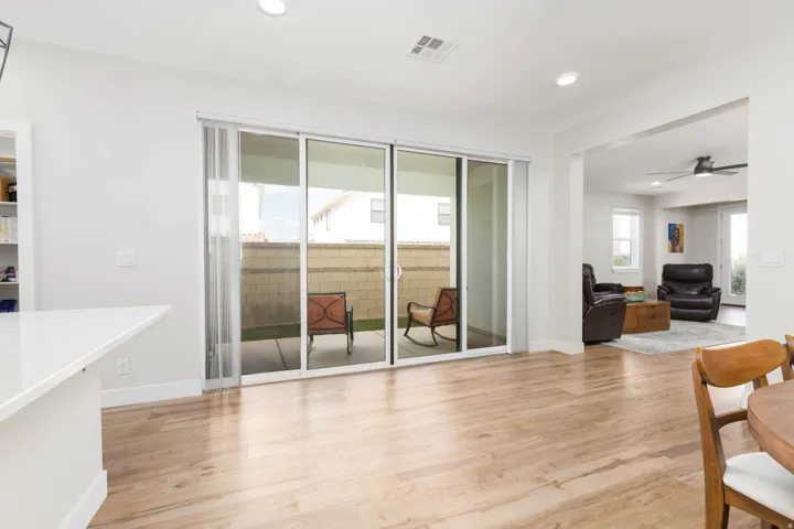 Wood-finish flooring, white walls, recessed lighting, and sliding glass doors