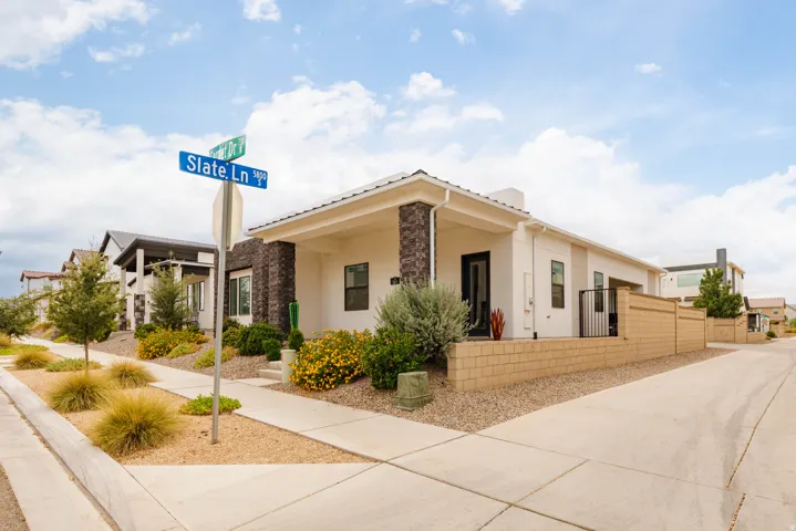 Modern residence featuring a clean-lined cream exterior with mixed material accents, including stone and fiber cement detailing