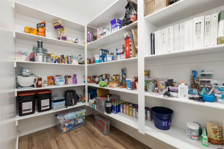 Extensive built-in shelving with white finishes and wood-finish flooring