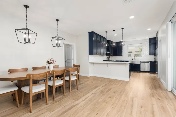 Open-concept living space featuring wood-finish flooring, recessed lighting, and sliding glass doors