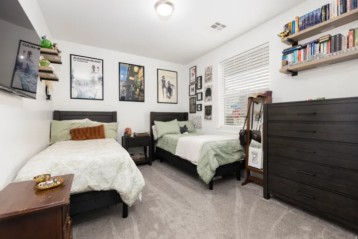 Recessed ceiling lighting, window with blinds, wall-mounted shelving, built-in shelving, and carpet flooring