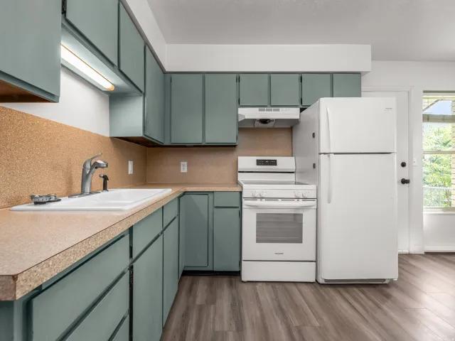 Kitchen featuring teal cabinetry, a white electric range, a white refrigerator, a white sink, and wood-finish flooring