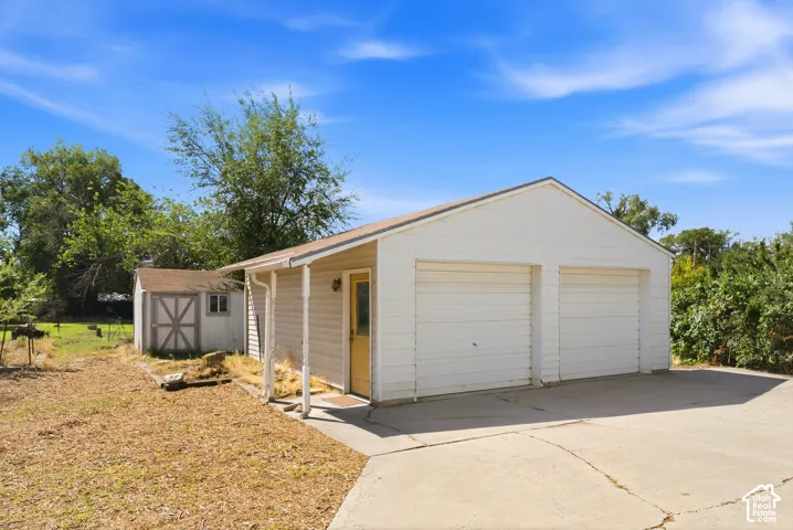 Two-car garage with white paneled doors, covered side entry, and concrete driveway
