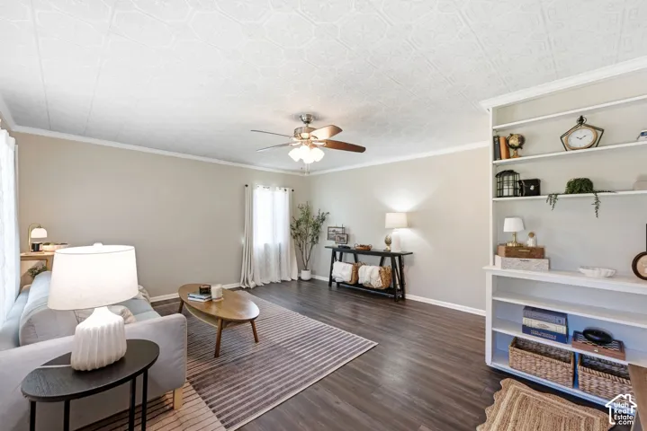 Recessed built-in shelving, wood-finish flooring, ceiling fan with integrated lighting, textured ceiling, and crown molding