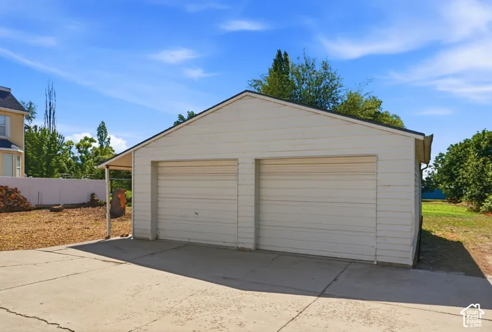 Detached two-car garage with white horizontal siding and a concrete driveway