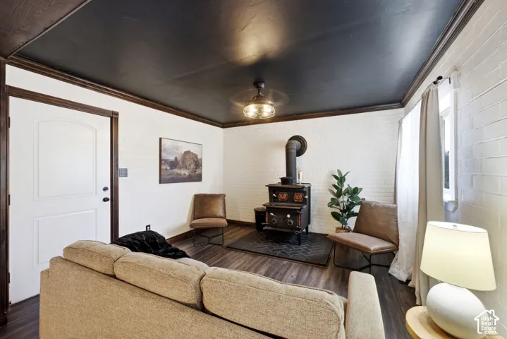 Wood-finish flooring, white brick-patterned wall, dark wood trim, and a black ceiling with a ceiling fan