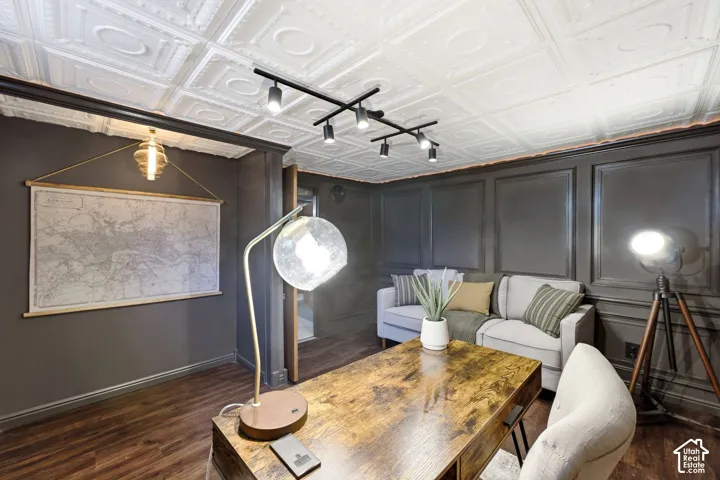 Bedroom/Office in basement Ceiling with decorative panels, track lighting, wood-finish flooring, and wall paneling