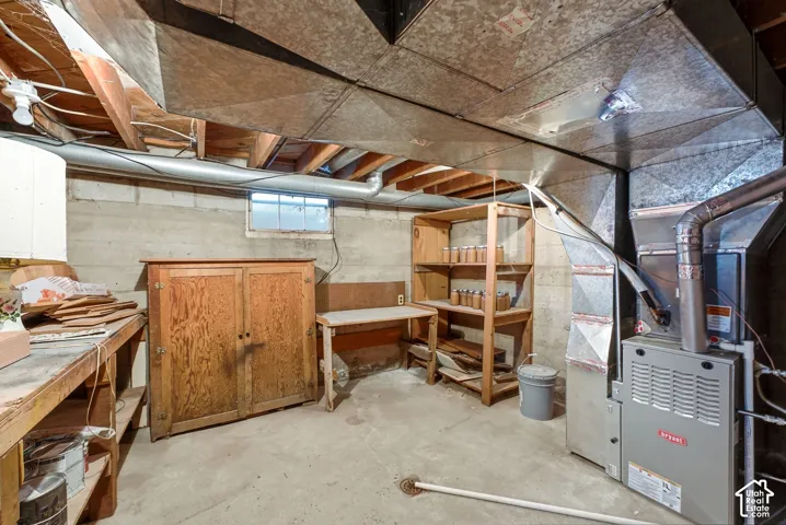 Utility space featuring exposed ceiling joists, a concrete floor, and a window