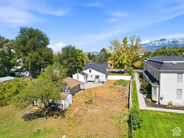 Expansive grounds featuring mature landscaping and established trees, with snow-capped mountain backdrop