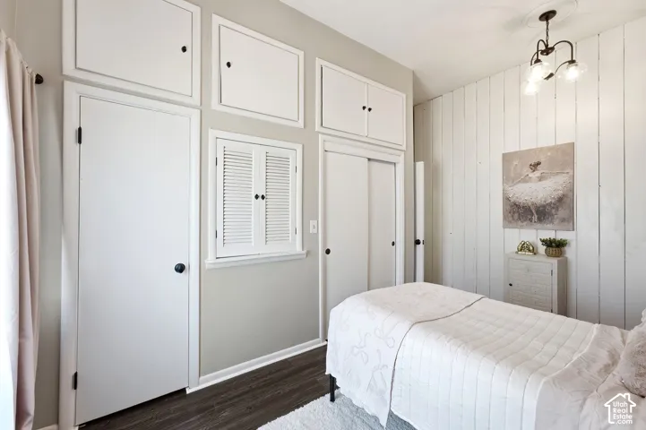 Horizontal wood-finish wall paneling, built-in overhead cabinetry, wood-finish flooring, and a ceiling-mounted light fixture