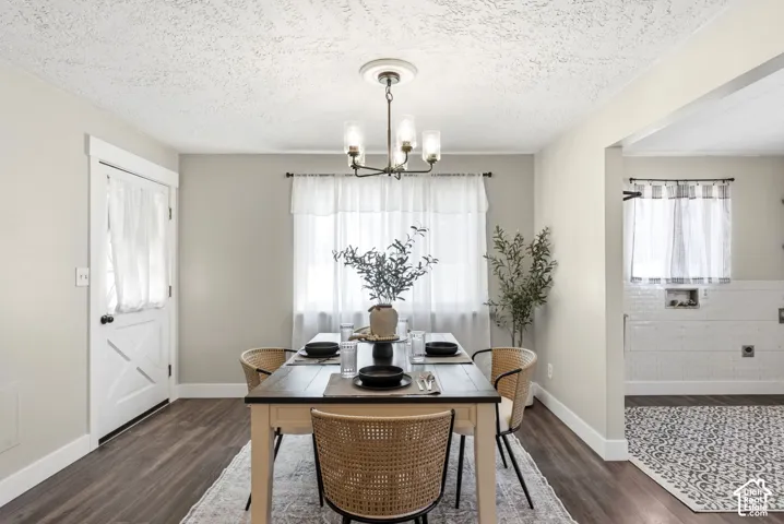 Wood-finish flooring, white barn-style door, ceiling-mounted light fixture, white tiled wall, and window with sheer curtains