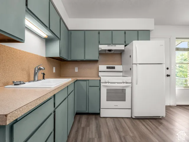 Kitchen featuring teal cabinetry, a white electric range, a white refrigerator, a white sink, and wood-finish flooring